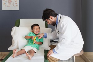 Doctor playing with boy in hospital.
